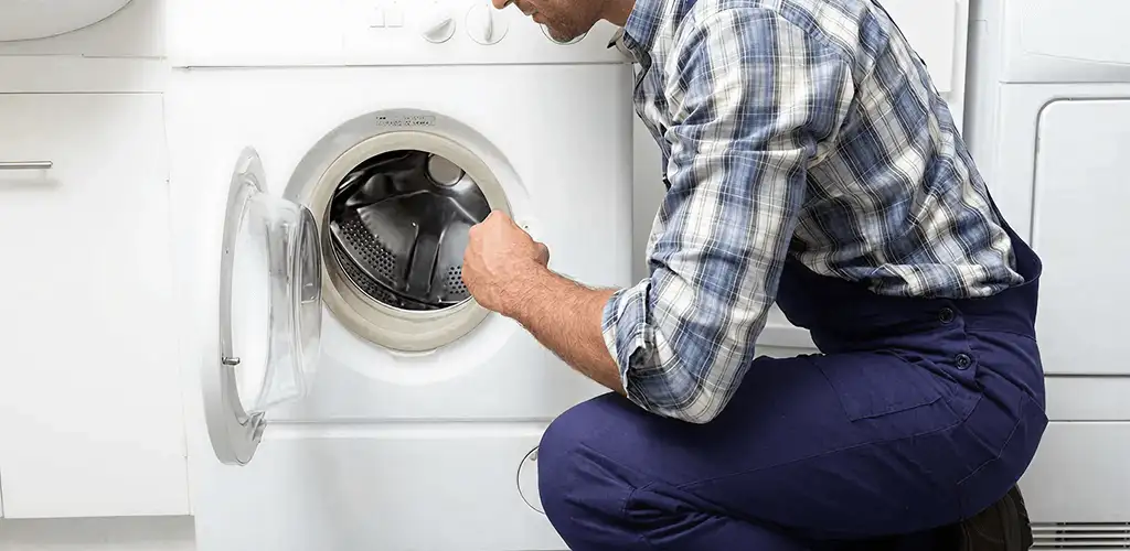 Handyman inspecting a dryer drum and internal parts for repair in Shreveport, LA