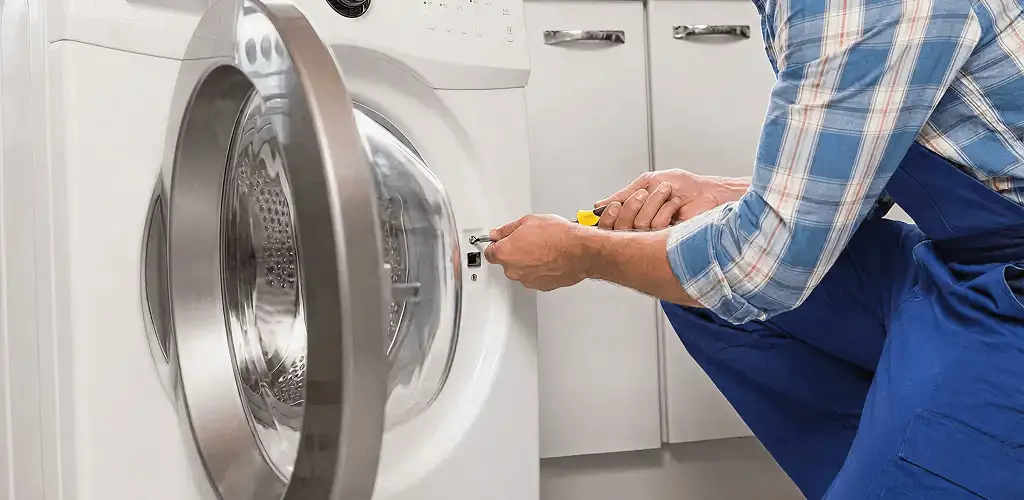 Handyman repairing a clothes dryer and checking electrical connections in Shreveport, LA