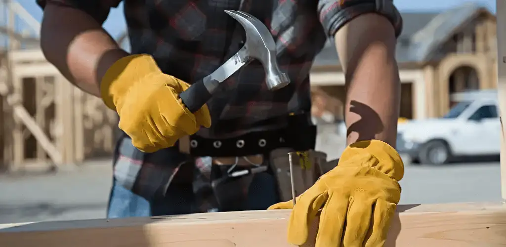 Handyman fixing wood trim with a hammer for home repairs in Shreveport, LA